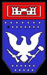 The Desert Ranger insignia is a blue shield capped with a castle in a red field.  Fifteen white stars in two rows above, and eleven more in two rows beneath a white eagle with a shotgun in his right claw and a sledgehammer in his left.